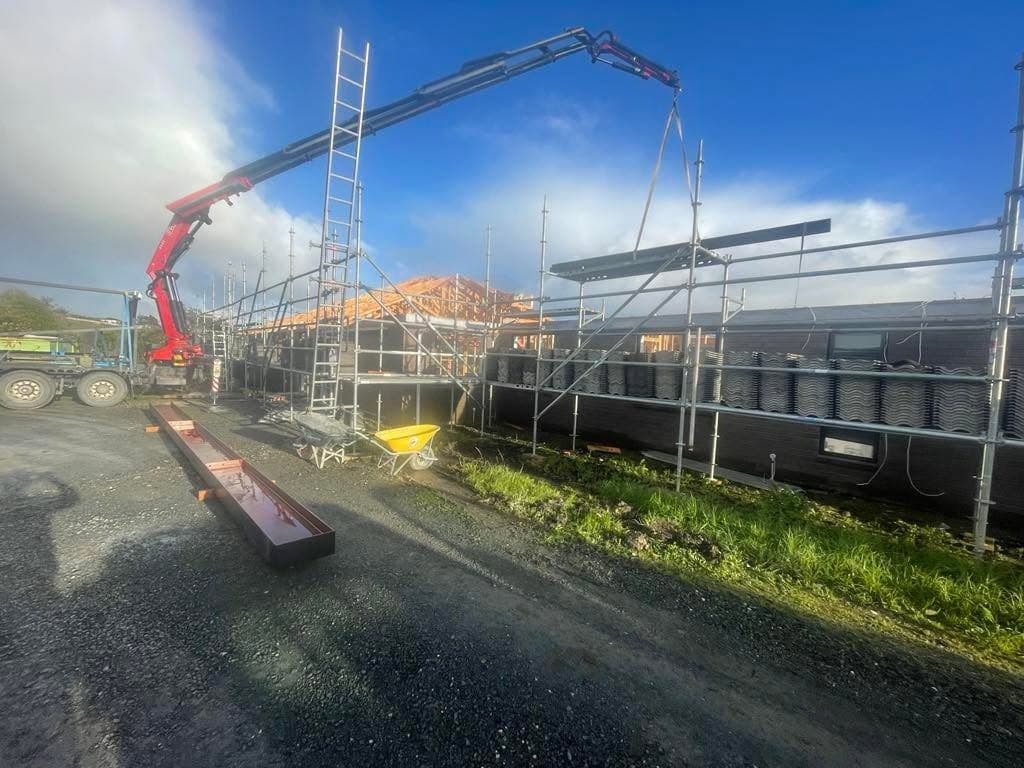Crane truck delivering materials to a framing site